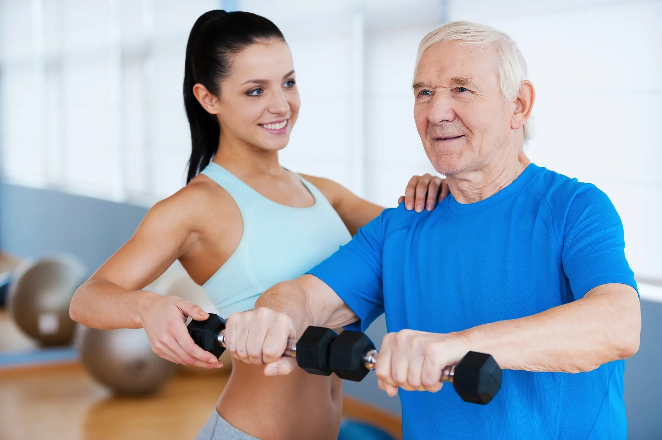 A woman and an older man are working out.