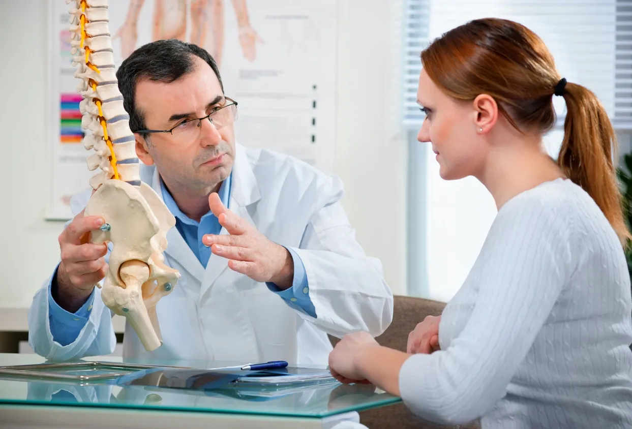 A doctor talking to a woman in an office.