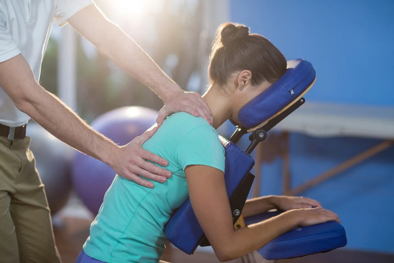 A person is holding on to the back of a chair.