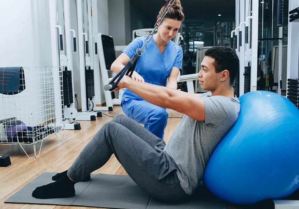 A woman is helping someone do some exercises