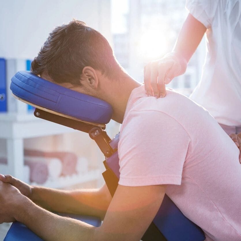 A man is getting his neck adjusted by a chiropractor.