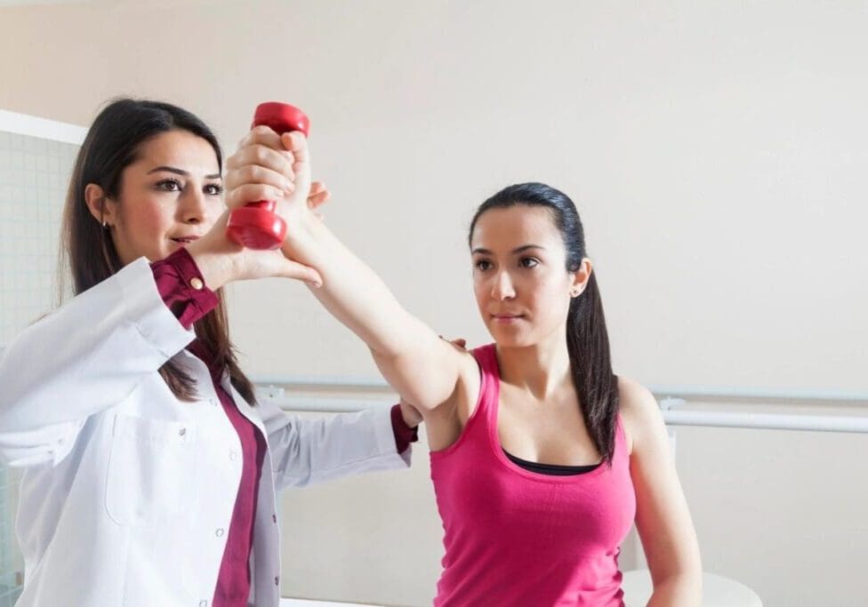 A woman holding onto a red object while another person watches.