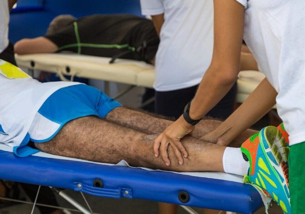 A person is getting his leg waxed on the beach.