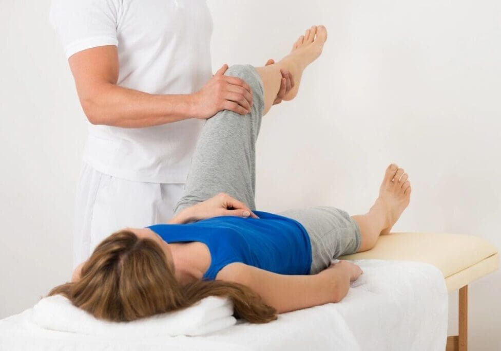 A woman is getting her leg examined by a doctor.