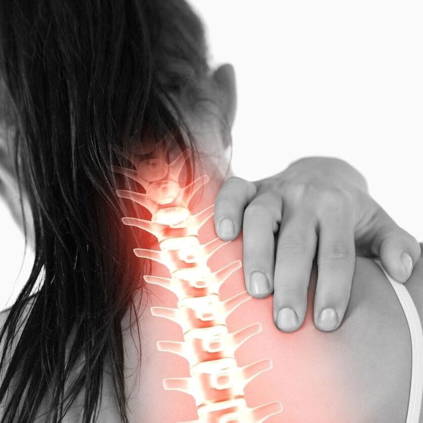 A woman holding her arm up to the side of her neck.