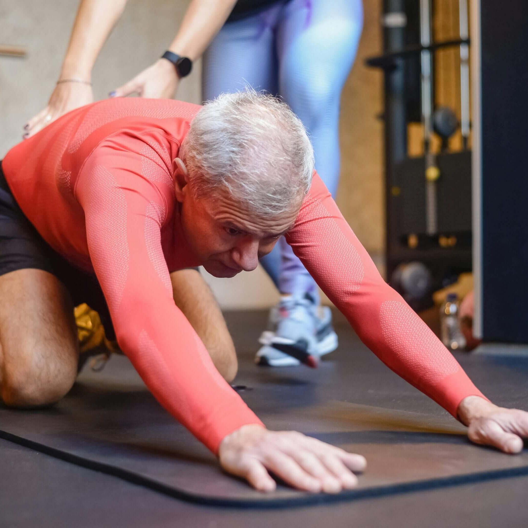 A man is laying on the ground while another person stands behind him.