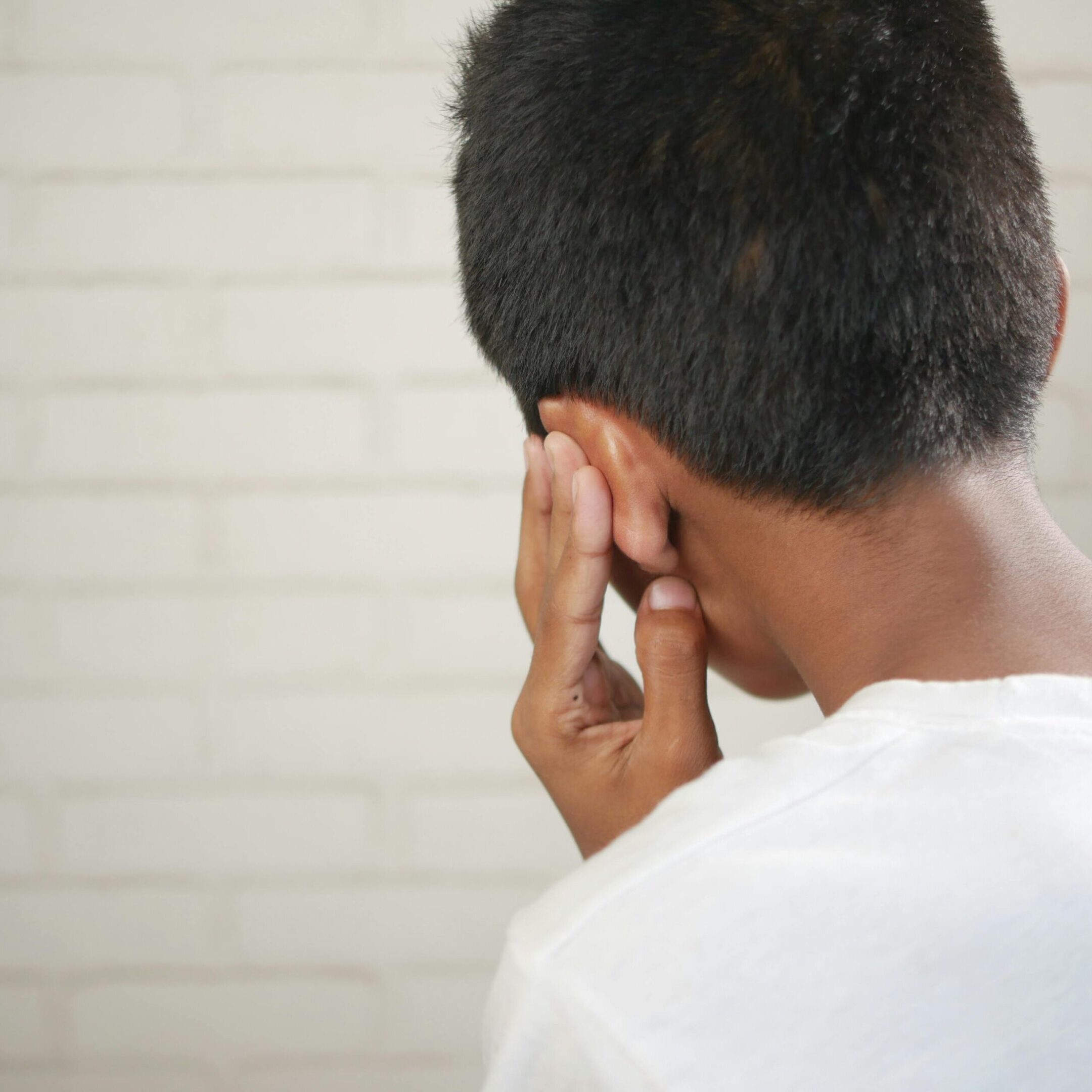 A man with his hand on the side of his head.